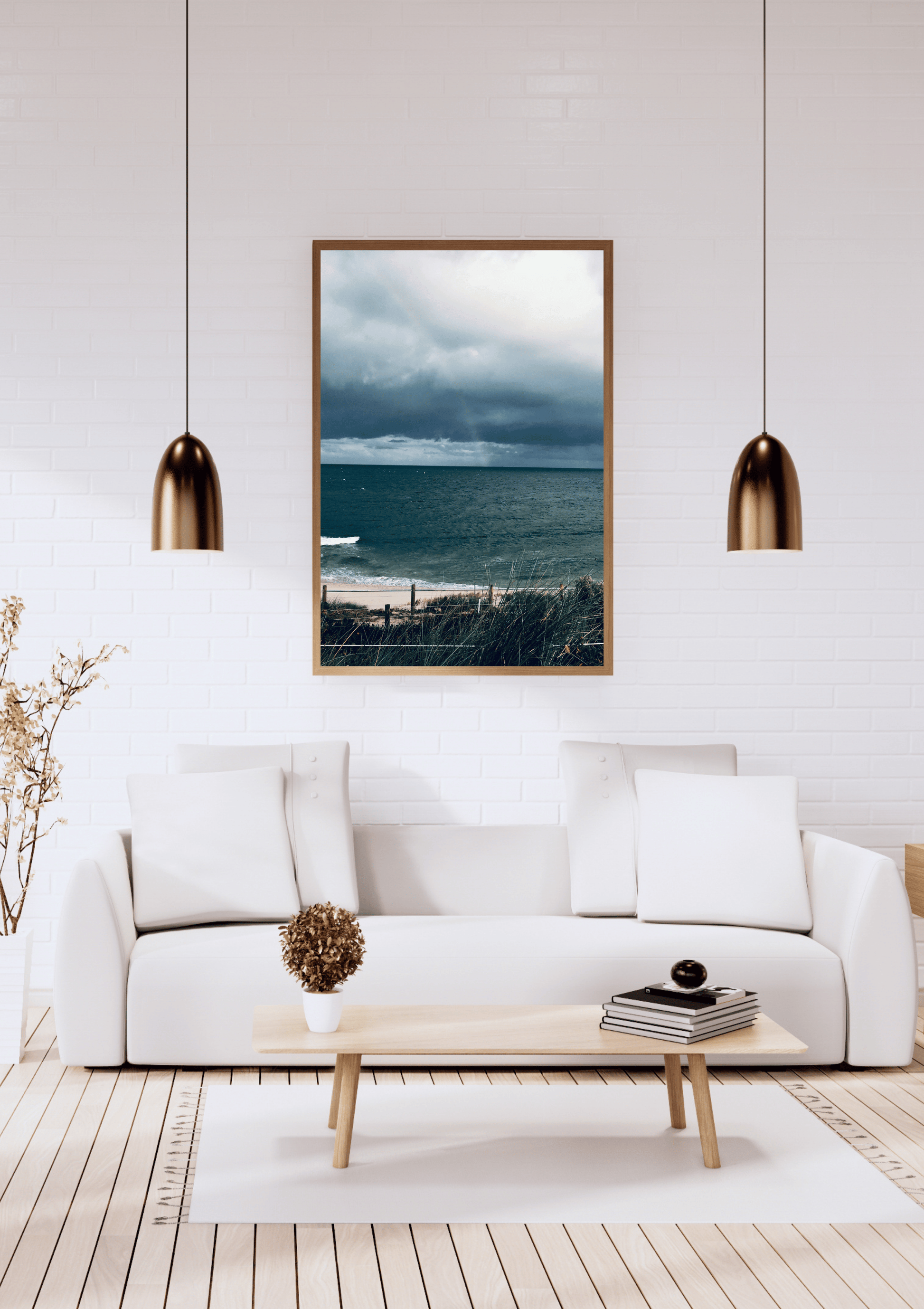 A framed vertical landscape print ofan aerial view of the crimson colour of the barren land in Australia above a modern white sofa in a bright living room. 