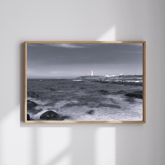 The Last Watcher fine art travel photography black and white print featuring a lighthouse in the distance with the ocean and shore at the forefront in Sydney, Australia