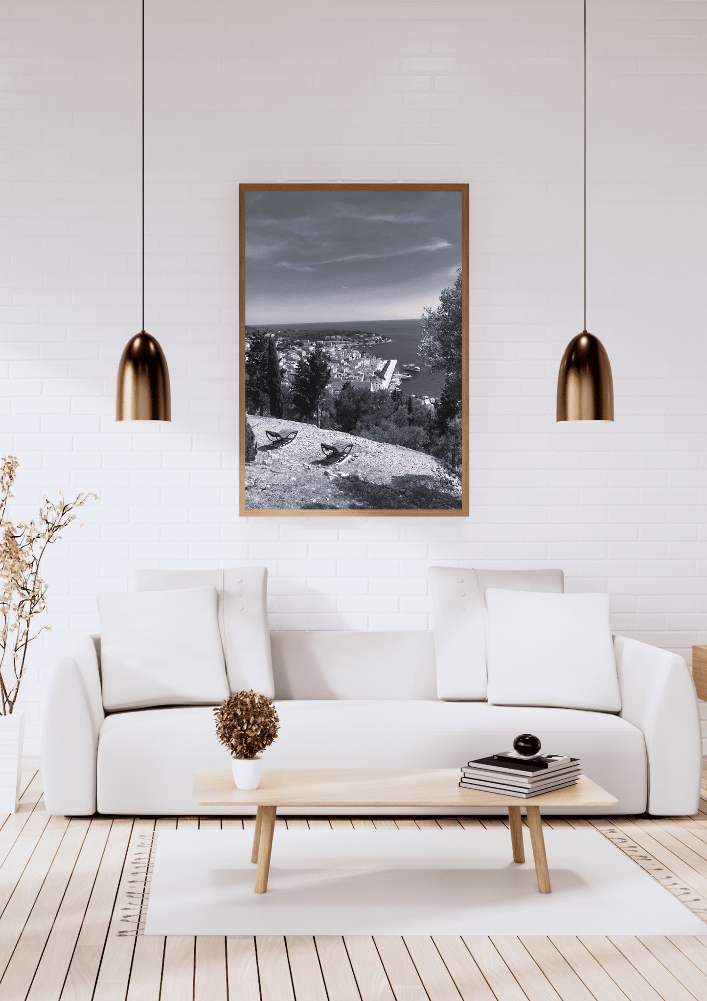 A framed black and white landscape photograph hanging on a white brick wall above a modern white sofa in a bright, contemporary living room.