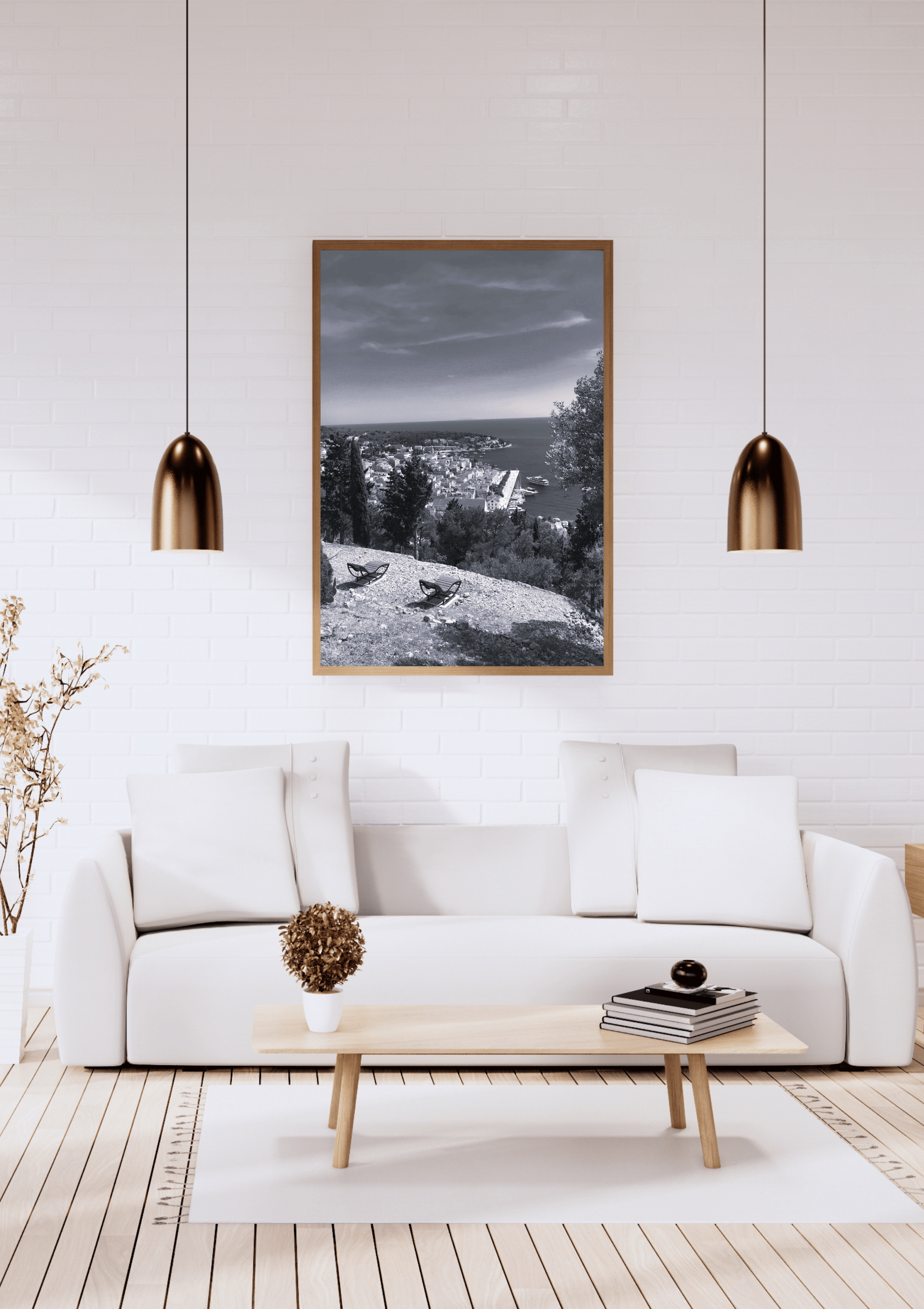 A framed black and white landscape photograph hanging on a white brick wall above a modern white sofa in a bright, contemporary living room.